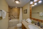 Third bathroom has a tub and tiled modern look